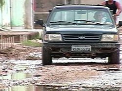 No bairro de Santo Aleixo, motorista tenta desviar da meljor forma os buracos da rua.